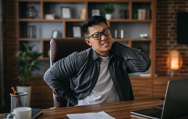 A-Guy-Sitting-Down-on-Desk-having-Neck-Pain-NoFrills-Chiropractic-Singapore