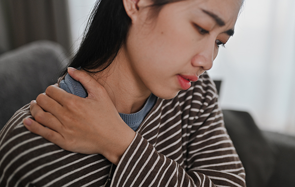 A-Lady-with-Stripped-Clothing-having-Shoulder-Pain-NoFrills-Chiropractic-Singapore