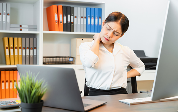 Office-Lady-Sitting-on-the-Desk-with-Bad-Posture-NoFrills-Chiropractic-Singapore