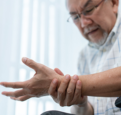 Elderly-man-holding-on-the-wrist-NF-chiropractic Female-Chiropractor-adjusting-White-T-shirt-Male-Patients-Arm-NoFrills-Chiropractic-Singapore