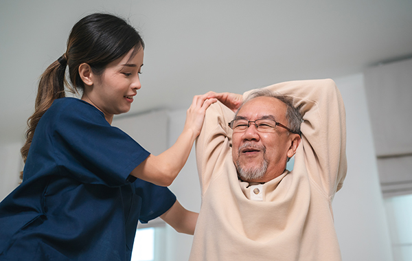 Male-Chiropractor-adjusting-Elderlys-Back-Side-Ways-in-Homebase-NoFrills-Chiropractic-Singapore