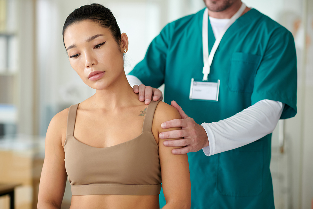 Palpating Shoulder of Sportswoman Checking Spine for Scoliosis